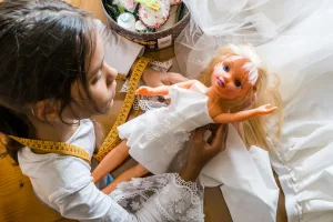 Little girl dressmaker working in atelier